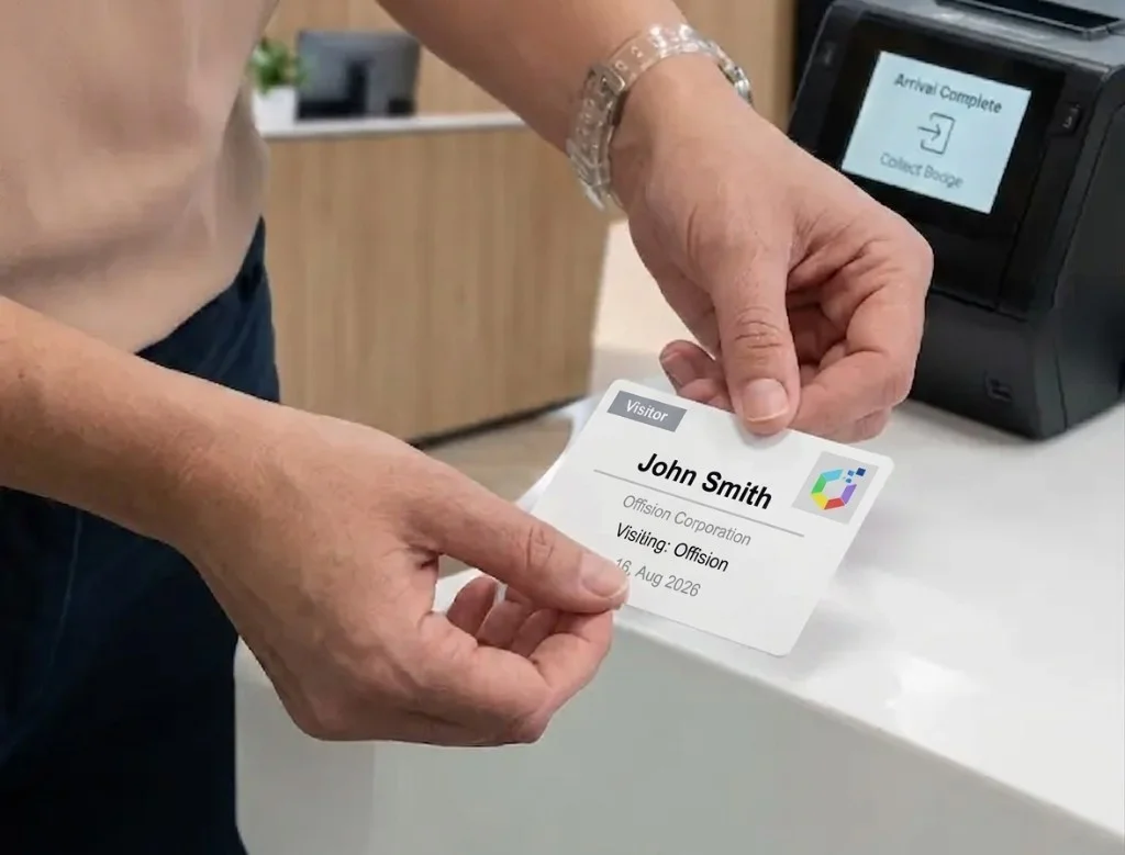 ロビーのプリンターから、John Smith と Offision ロゴが印刷された来訪者バッジを両手で受け取っている。画面には Arrival Complete と表示されている。
